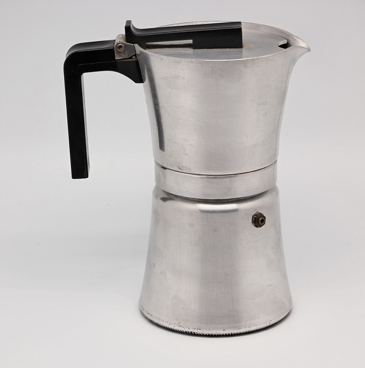 A stainless steel moka pot next to a classic aluminum moka pot, both gleaming on a kitchen stovetop.